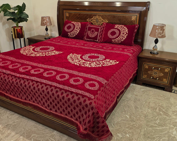 Red patterned bedspread on a wooden bed with matching headboard and nightstands.