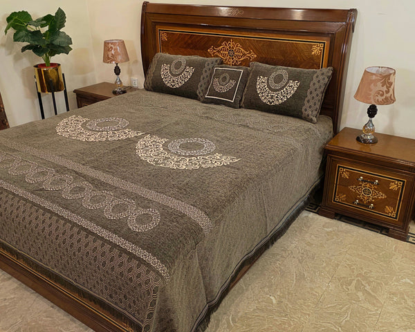 Bedroom with a wooden bed and matching nightstands, featuring decorative pillows and a plant.