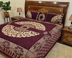 Decorative bedspread with intricate patterns on a bed in a bedroom setting.