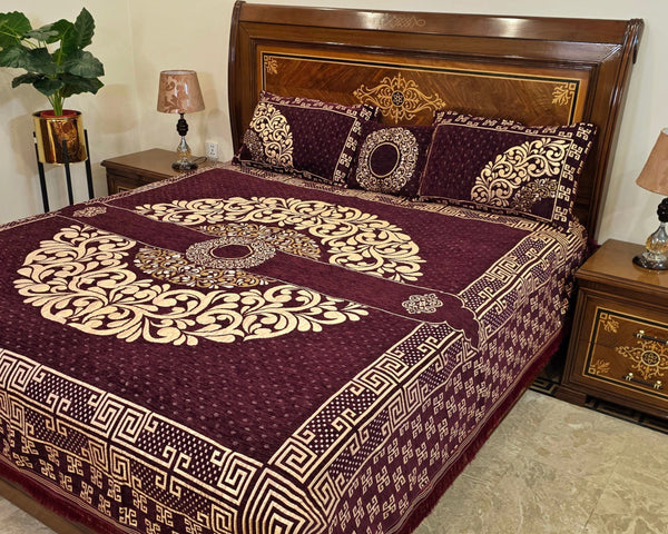 Decorative bedspread with intricate patterns on a bed in a bedroom setting.