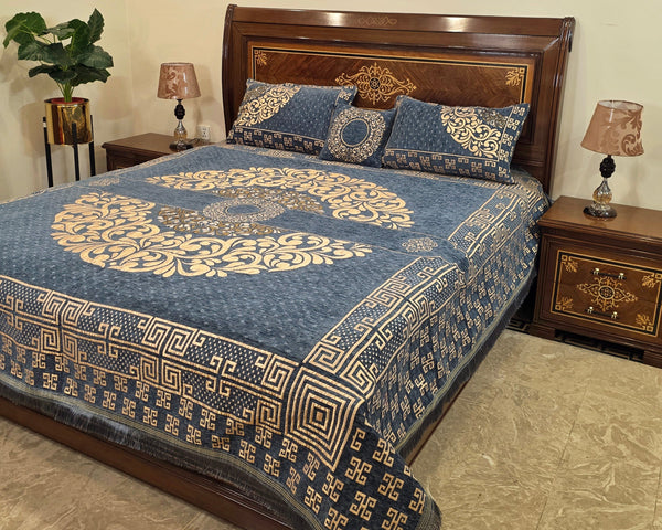 Bed with blue and gold patterned bedding in a bedroom setting.