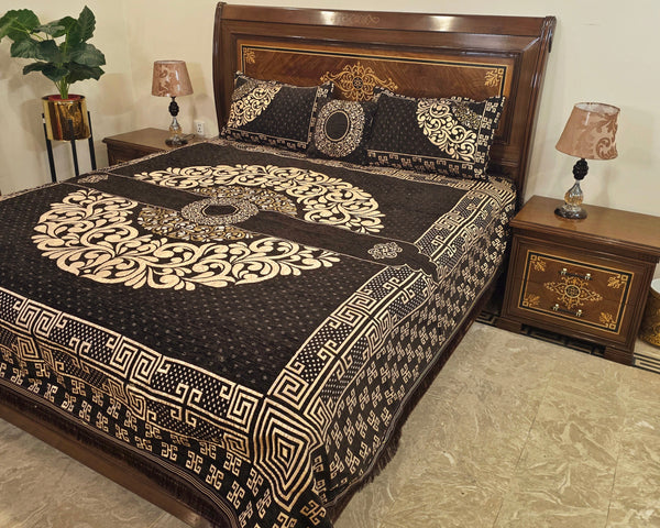 Decorative bedspread with intricate patterns on a bed in a room setting.