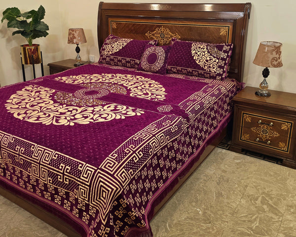 Bed with purple and gold patterned bedding in a bedroom setting.