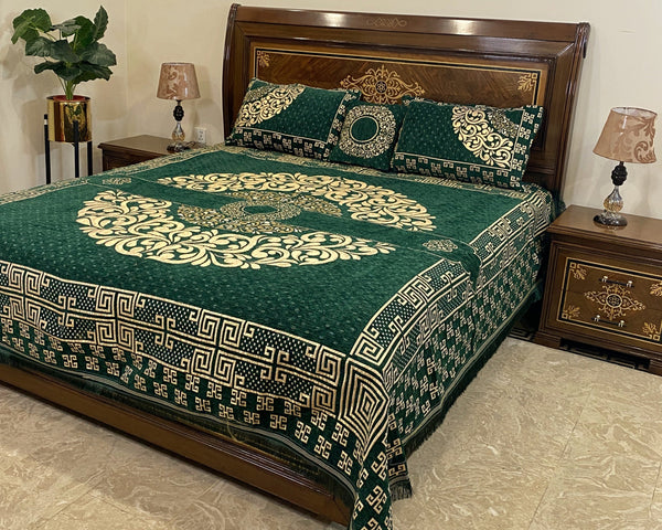 Decorative green and gold bedspread on a bed in a bedroom setting.